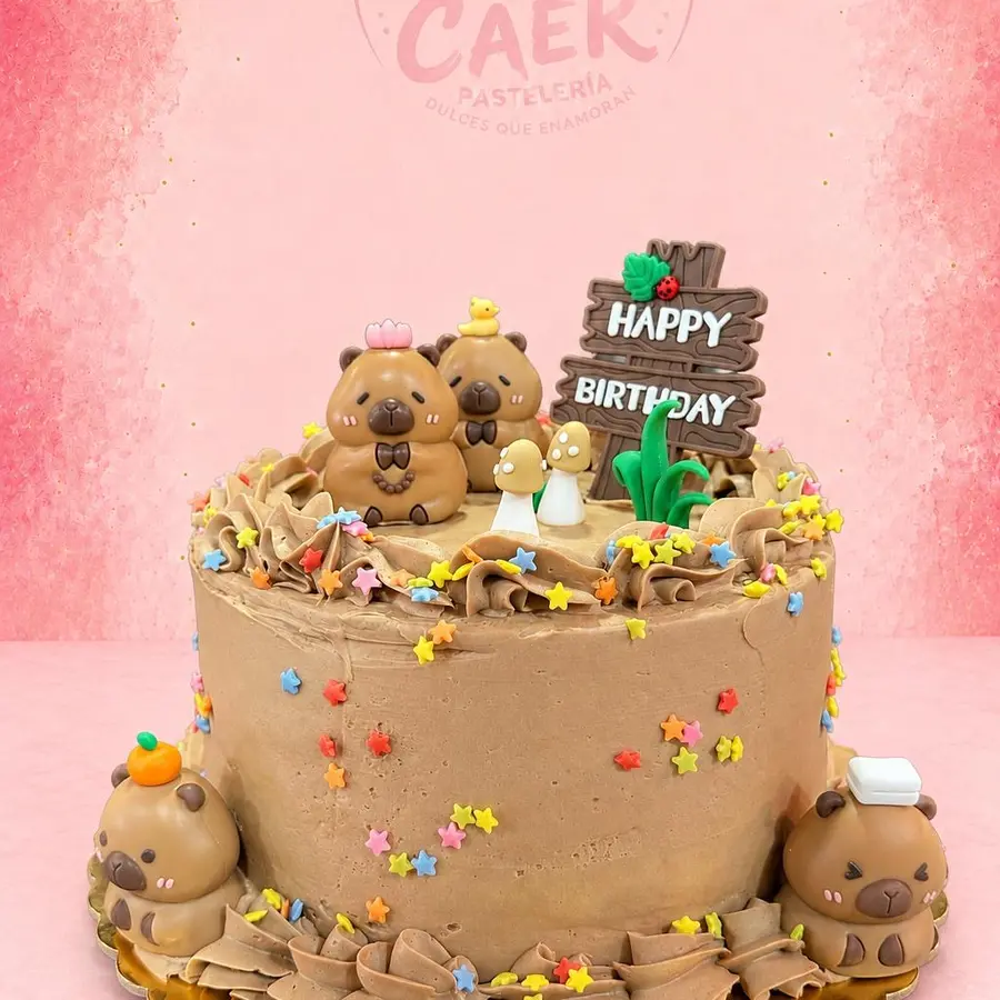 Tarta de cumpleaños infantil de chocolate decorada con capibaras y estrellas de colores